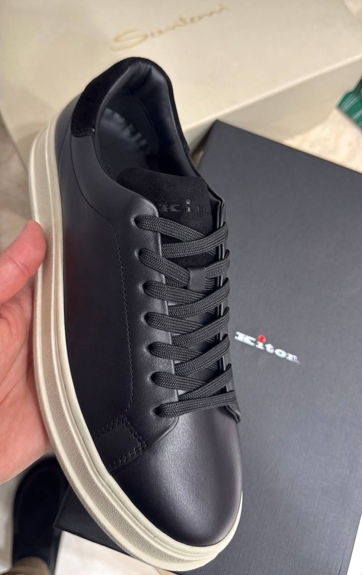 une basket basse en cuir noir Kiton.
